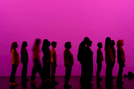On a fuchsia background, the silhouettes of thirteen people of different ages (from teenagers to older adults) stand in profile, all facing the right side of the stage.